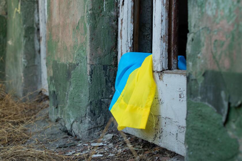 A destroyed building and a broken door from the explosion and next to it lies the flag of Ukraine in the city of Dnepr in Ukraine, war