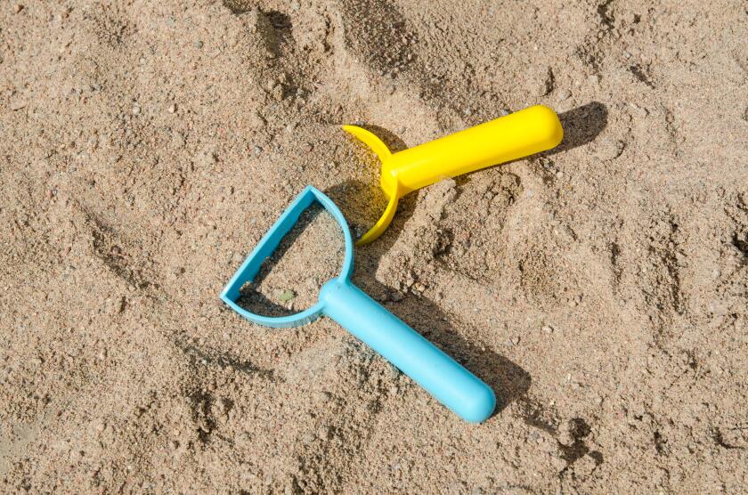 Closeup of plastic toys in a sandbox - conceptual sandbox level