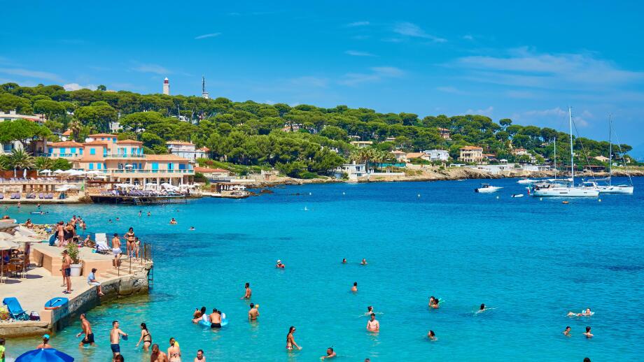 Scenic Seaside Beach Resort with Tourists Enjoying Swimming and Relaxing Under Umbrellas at La Garoupe beach, Cap d'Antibes, Cote d'Azur, France