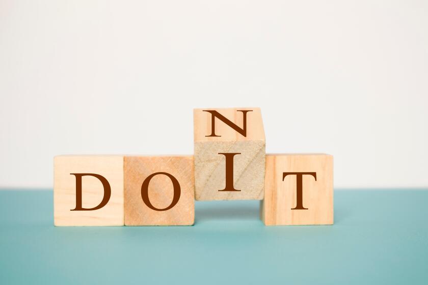 Hand flipping one wooden cube to change the word Don't for Do it on neutral background