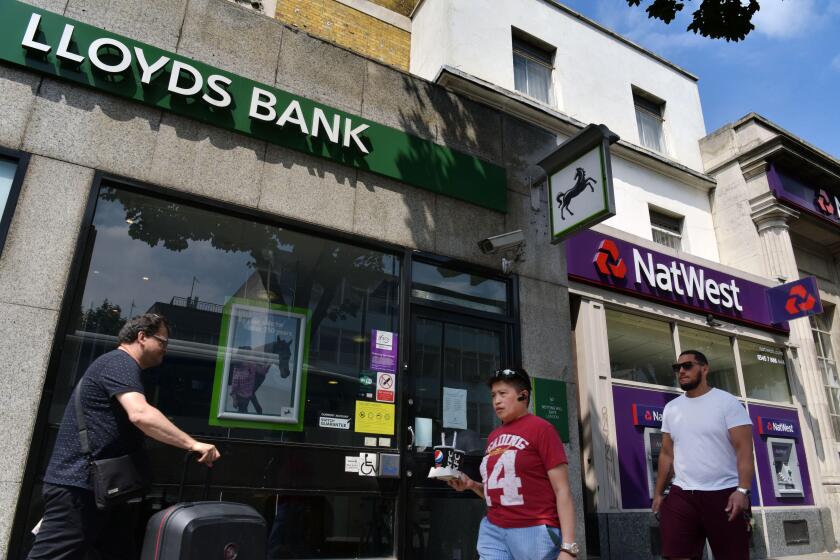 People walk past the branches of NatWest and Lloyds banks in Notting Hill London