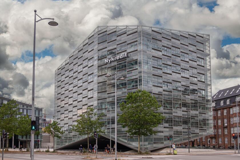 Copenhagen, Denmark - July 24, 2022: Modern gray, glass and steel Nykredit bank building at corner of Puggaardsgade and Kalvebod Brygge under blue clo