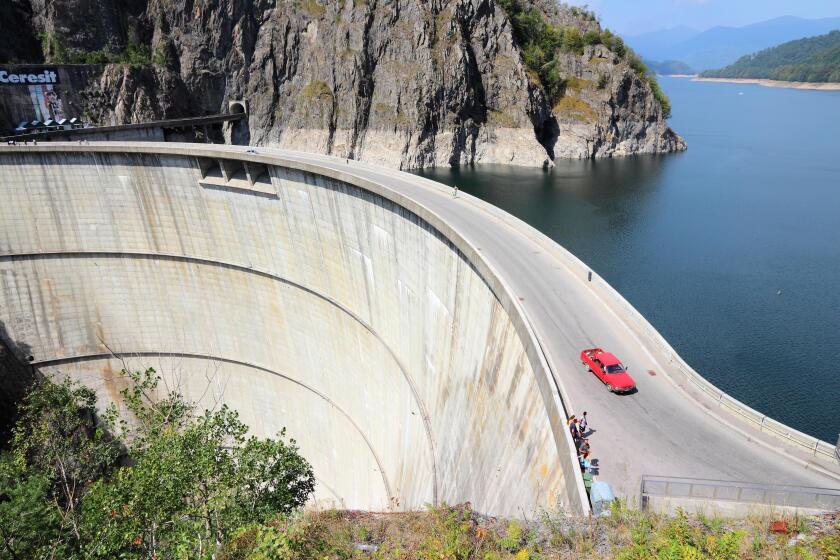 VIDRARU DAM, ROMANIA - AUGUST 23, 2012: People visit Vidraru Dam in Romania. Vidraru Hydro Power Plant has an installed capacity of 220 megawatts.