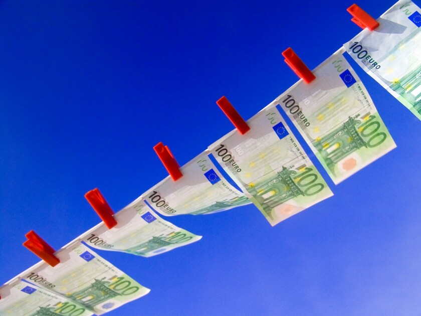 EURO NOTES WASHING LINE Crisp new 100 Euro notes fluttering flying high in the breeze pegged in a line against a sunny blue sky Horizontal Landscape