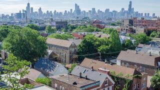 Aerial view of West Town, Bucktown, and Wicker Park neighborhoods with Chicago skyline in background.