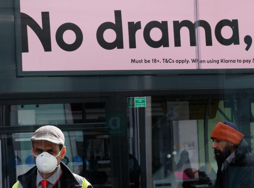 Birmingham, West Midlands, UK. 31st March 2020.  A masked man stands in a Birmingham city centre bus shelter during the Coronavirus pandemic lockdown. Credit Darren Staples/Alamy Live News.