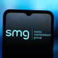 In this photo illustration, the SMG Swiss Marketplace Group logo is seen displayed on a smartphone screen.