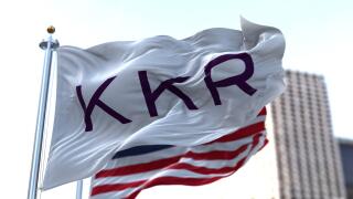 New York, USA, November 2021: The flag With KKR logo waving in the wind with the American national flag blurred in the background