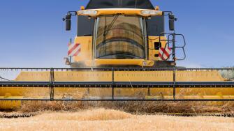 close front view of modern combine harvester in action.