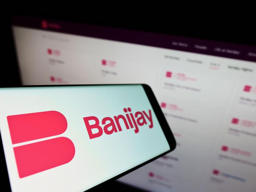 Smartphone with logo of French entertainment company Banijay Group on screen in front of business website. Focus on center-left of phone display.