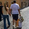 Rome, Italy. July 4, 2026, Rome, Italy: The man of a tourist couple carries three paper bags after purchasing on the day the summer sales begin in Rome. End-of-season summer sales began today in all Italian regions, with the exception of the autonomous pr