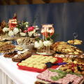Lavishly decorated dessert buffet table with a variety of pastries, cookies, cakes, and sweets, beautifully arranged with floral decor.