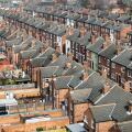 An aerial view above the rooftops of run down back to back terraced houses on a large residential estate in the North of England