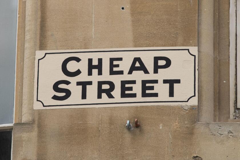 Painted road sign reading Cheap Street on a stone building in the historical City of Bath, Somerset, UK