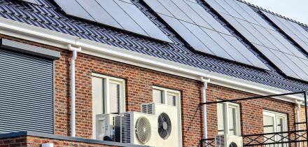 Air source heat pump unit installed outdoors at a modern home with solar panels in the Netherlands