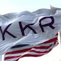 New York, USA, November 2021: The flag With KKR logo waving in the wind with the American national flag blurred in the background