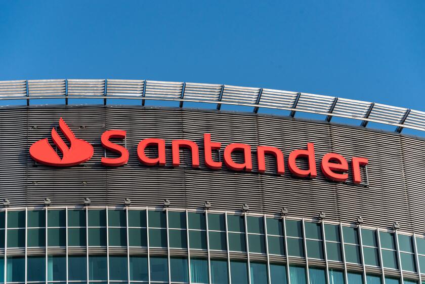 Santander Bank trademark, logo against blue sky on the top of  high class office complex located in the center of Poznan Financial Centre. Poland