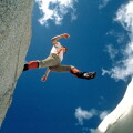 A hiker jumps over a crevasse on a glacier high in the Canadian Rockies in Banff National Park. Image shot 2003. Exact date unknown.