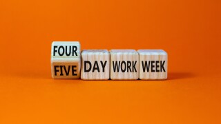 4 or 5 day work week symbol. Turned the cube and changed words 'five day work week' to 'four day work week'. Beautiful orange background. Copy space. Business and 4 or 5 day work week concept.