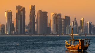 Dhow traditional sailing vessel with the financial area skyline behind, Doha, Qatar