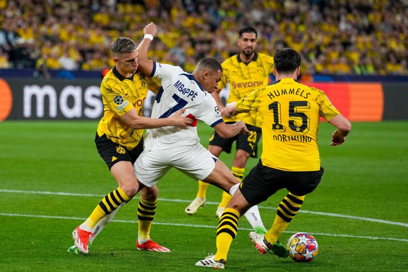 PSG's Kylian Mbappe, center, is challenged by Dortmund's Nico Schlotterbeck, left, and Mats Hummels during the Champions League semifinal first leg soccer match between Borussia Dortmund and Paris Saint-Germain at the Signal-Iduna Park in Dortmund, German