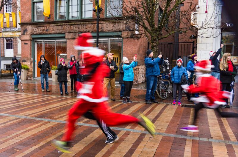 Burlington, Vermont / USA - December 2,2018: the blur of runners dressed as Santa Claus running 5 km for charity in town