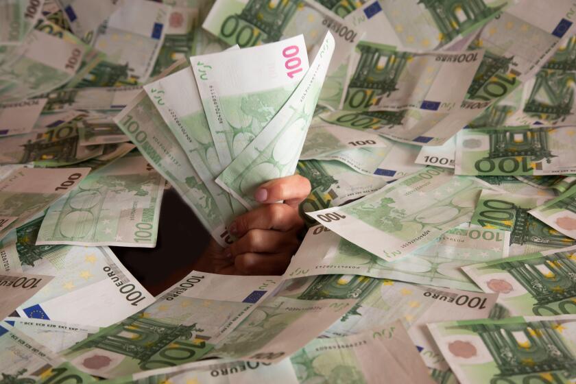 hand with euro banknotes climbs out of a mountain of money