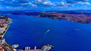 Aerial drone view of Bosphorus Strait with Dolmabahce Palace waterfront, ferries crossing between Europe and Asia, Istanbul, Turkey