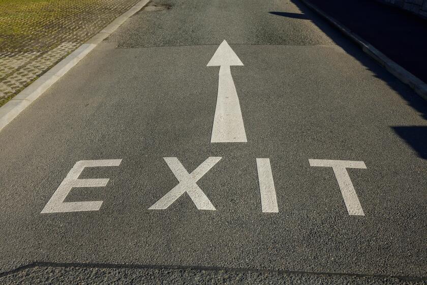 An Exit sign and arrow painted on a road in the UK