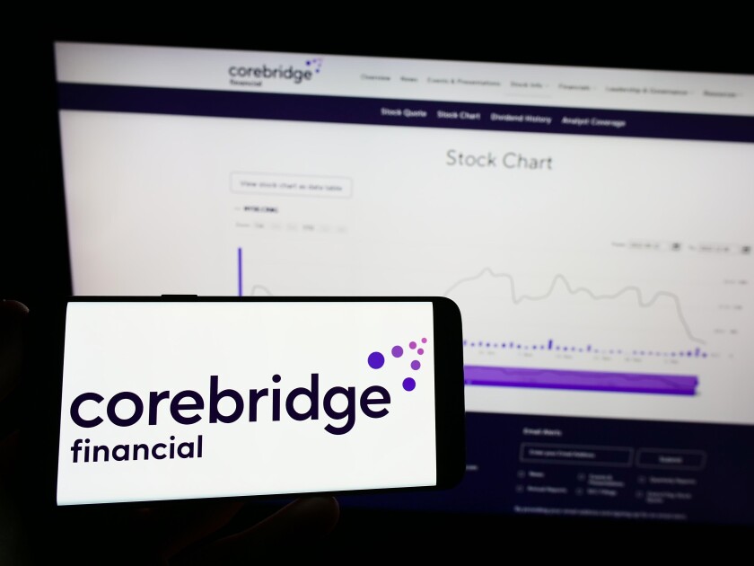 Person holding mobile phone with logo of American company Corebridge Financial Inc. on screen in front of web page. Focus on phone display.