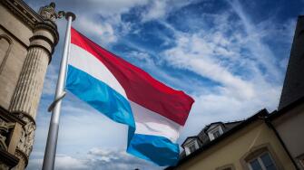 Luxembourg flag flying among historic buildings in the capital