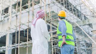 engineer standing with arub property investor looking under construction building for new properties  projects in middle east country