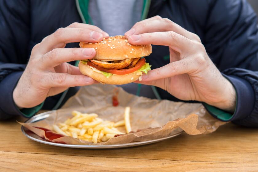 close up view of man's hands with american burger.