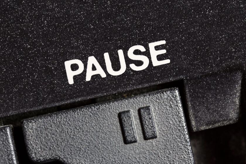 Macro close up photograph of vintage tape machine play and record pause button.
