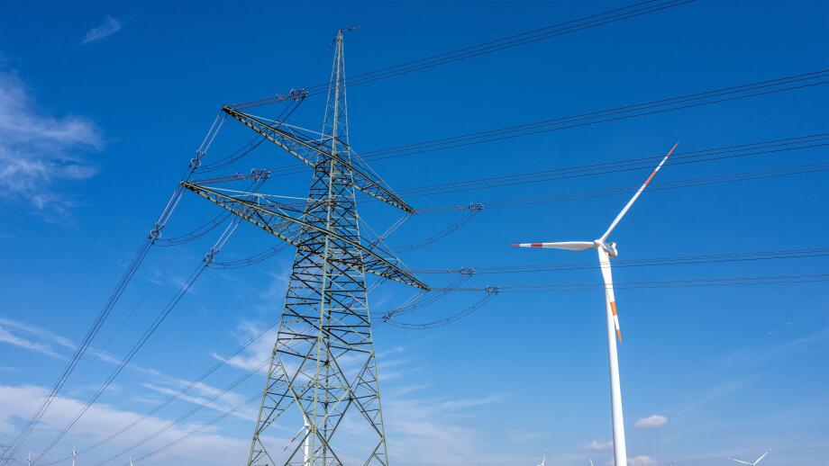 An electricity pylon with wind turbines seen in Germany