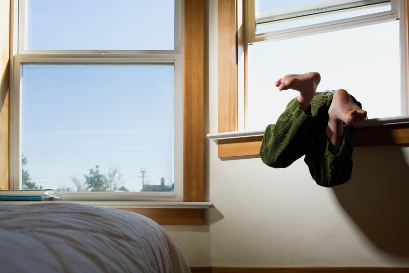 Boy climbing out of window