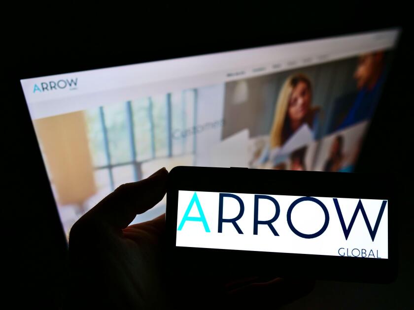 Person holding smartphone with logo of British investment company Arrow Global Group Plc on screen in front of website. Focus on phone display.