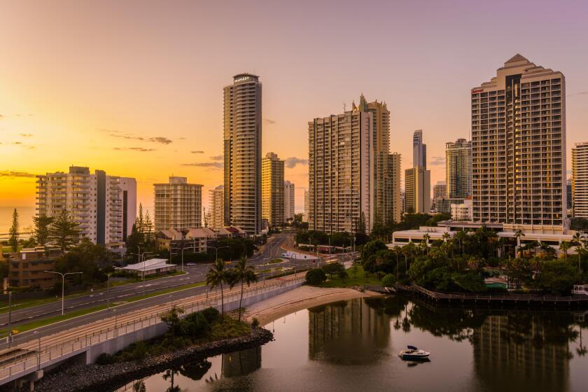 A spectacular sunrise illuminates the Surfers paradise high-rise apartments with beautiful golden light.bordering the ocean and the canal development.
