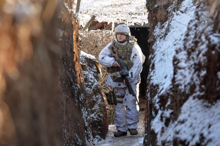 A service member of the Ukrainian armed forces walks in a trench at combat positions near the line of separation from Russian-backed rebels outside the settlement of Zaitseve in the Donetsk region, Ukraine February 5, 2022. REUTERS/Oleksandr Klymenko