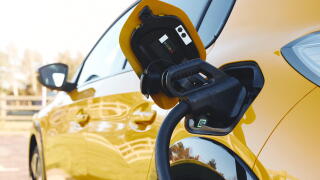 Close up of power supply plugged into an electric car being charged using a rapid charger cable