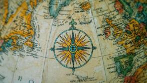 Close-up of a vintage globe showing Europe and the North Atlantic with a detailed compass rose.