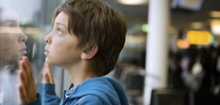 Young boy looking through a window