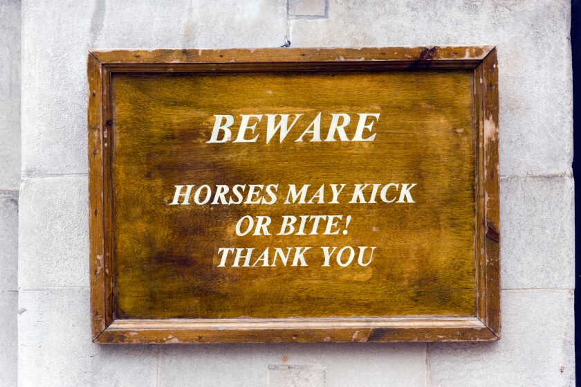 Beware, horses may kick or bite warning sign outside Horse Guards Parade on Whitehall, London, UK