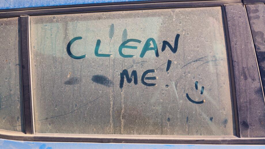 The inscription Clean me on a dirty car with a smile.