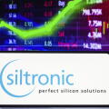 In this photo illustration the Siltronic AG logo seen displayed on a smartphone screen, with graphic representation of the stock market in the backgro