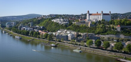 Bratislava Castle and the Old Town skyline over the Danube River, with bridge traffic and city landmarks on a clear day
