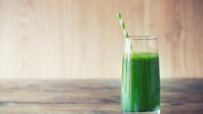 Green smoothie on vintage wooden background