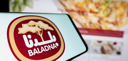 Stuttgart, Germany, 11-03-2023: Person holding cellphone with logo of Qatari dairy and food company Baladna in front of business website. Focus on