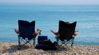Two people soak up the sun on the beach