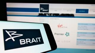 Cellphone with logo of investment company Brait SE on screen in front of business website. Focus on center-right of phone display.